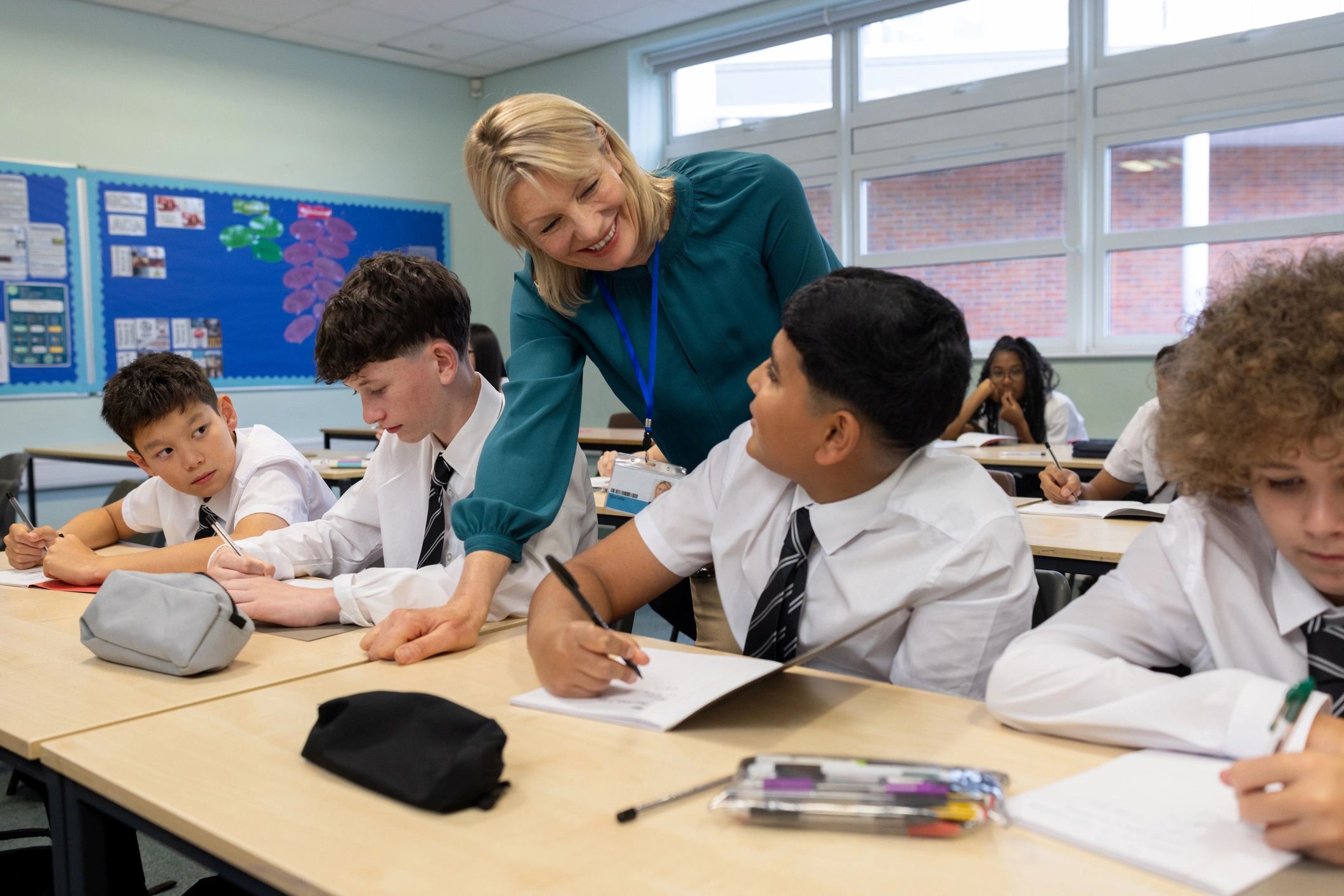 Teacher supporting students in an interactive classroom