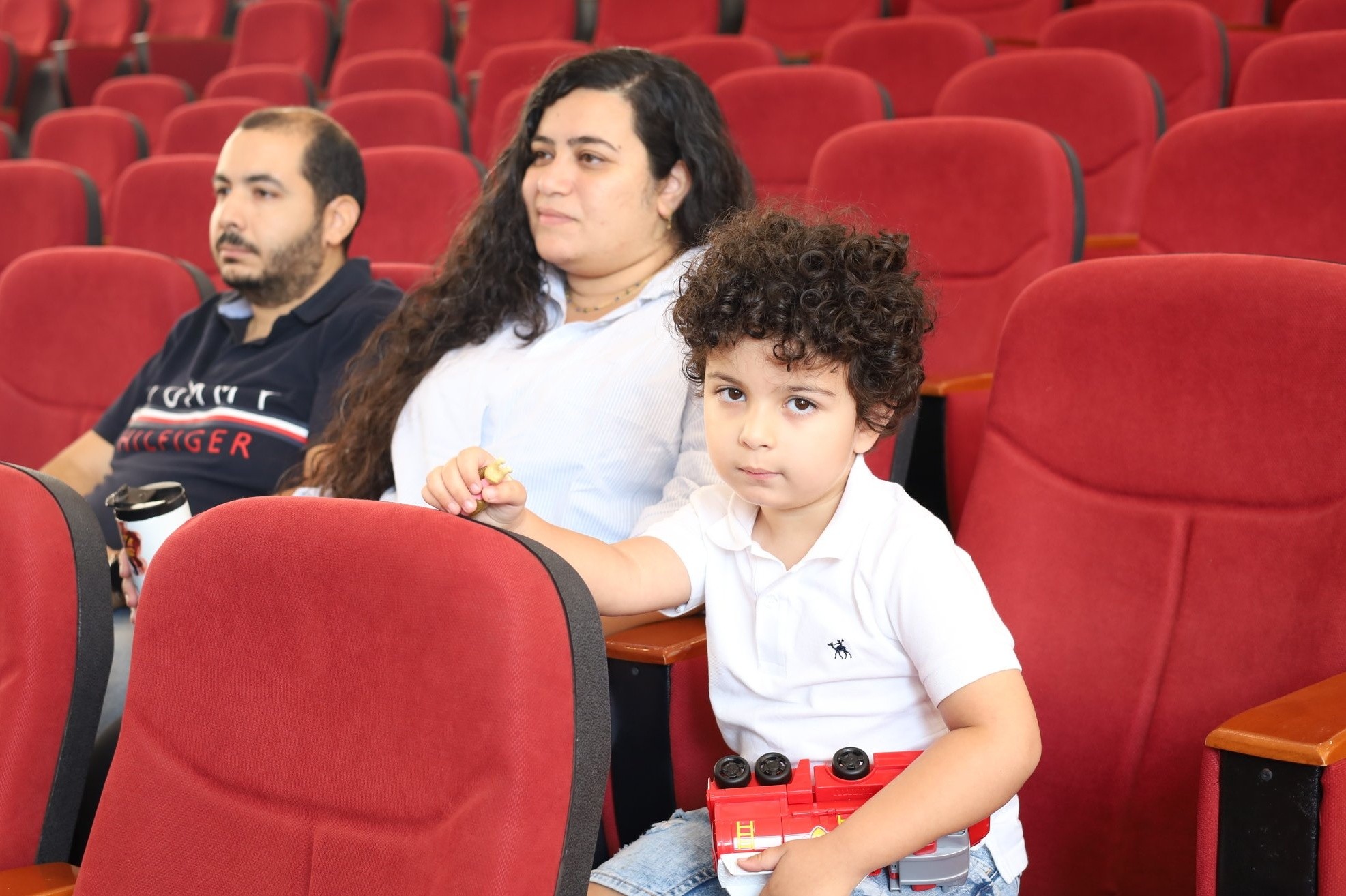 Parent and child attending a Royal Kings Schools event in the auditorium